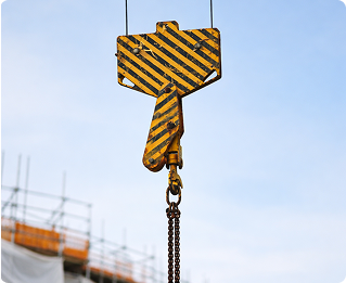 Yellow crane hook against a blue sky